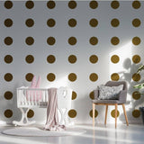 Gold circle wall decals in a nursery with white furniture and pink accents, adding a magical touch to the space.