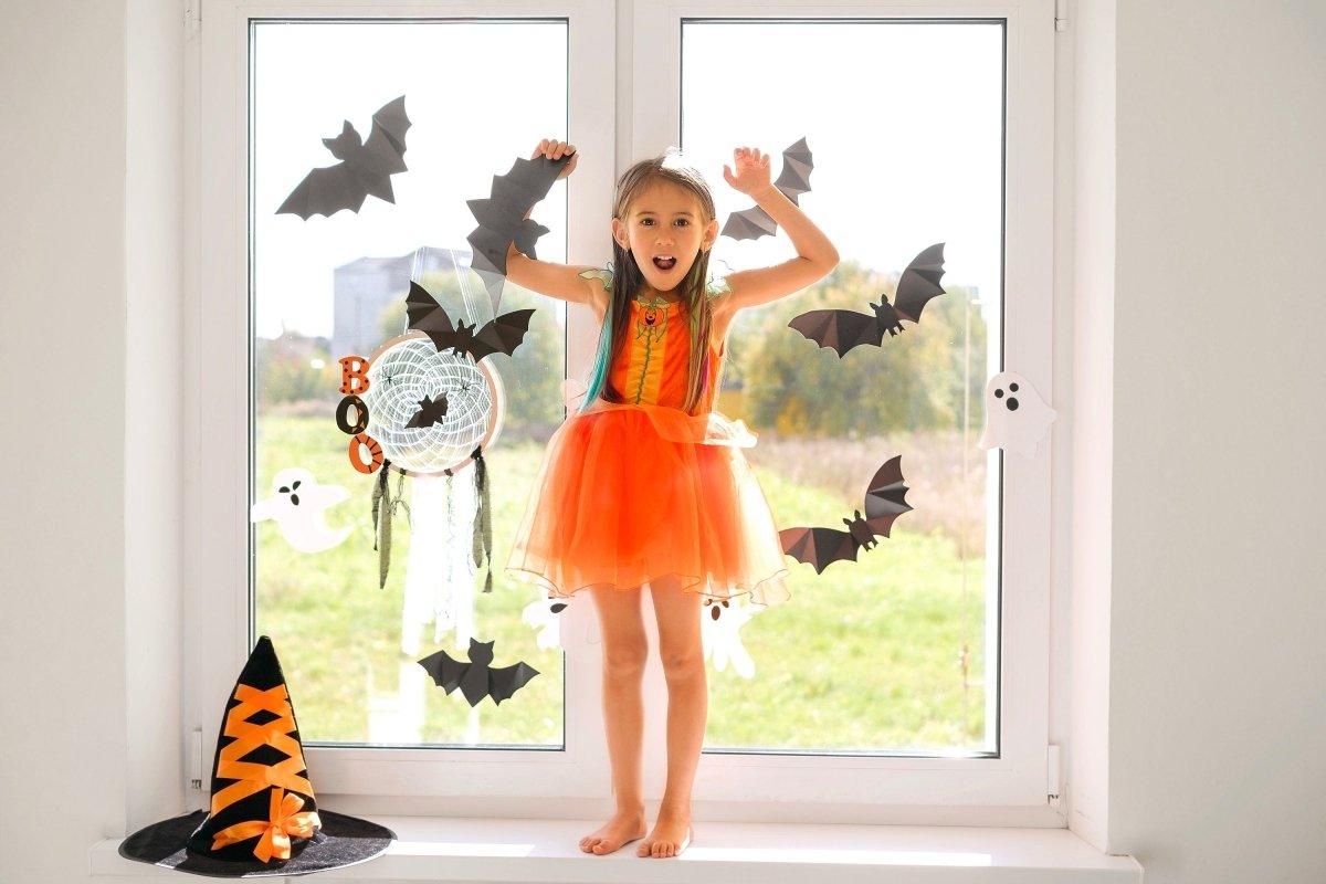 Bat-shaped silhouette vinyl decals displayed on a window in a decorated room.