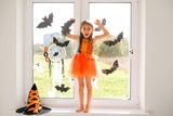 Bat-shaped silhouette vinyl decals displayed on a window in a decorated room.