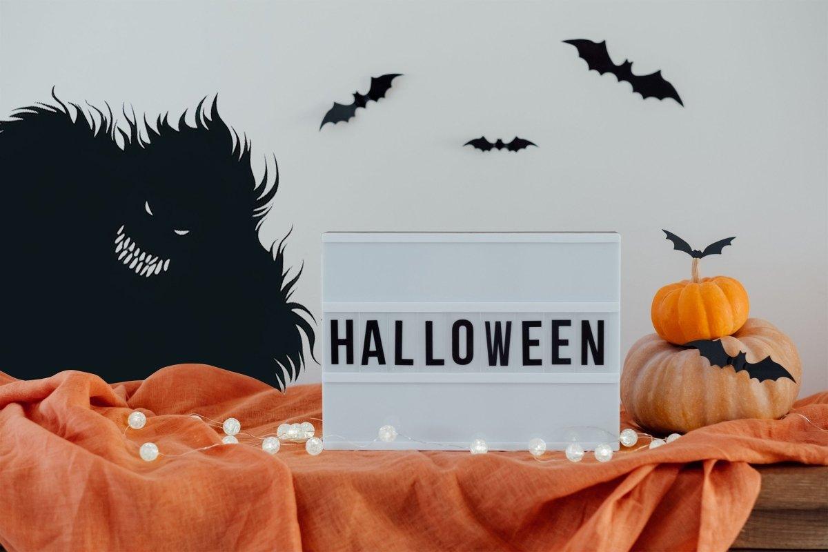 Halloween wall stickers with monster silhouette, bats, and decorative pumpkin on a table.