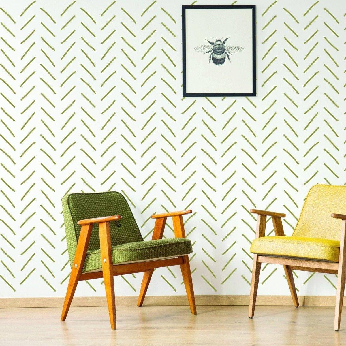 Peel and stick herringbone wall stickers in green, enhancing a cozy living space with stylish chairs and wall art.
