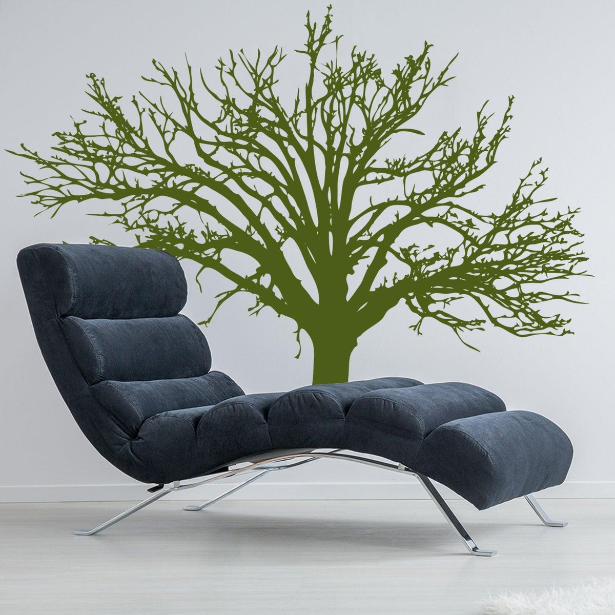 Stylish wall decal of an intricate green tree behind a modern lounge chair.
