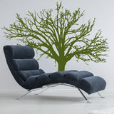Stylish wall decal of an intricate green tree behind a modern lounge chair.