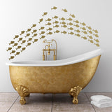 Gold fish vinyl wall stickers above a luxurious bathtub, adding a charming ocean theme to the bathroom decor.