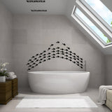 Fish vinyl wall sticker set decoration above a modern bathtub in a stylish bathroom with natural light.