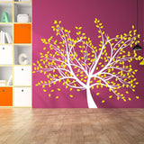Bright tree wall decal with yellow leaves on a purple wall, creating a vibrant nursery decor.