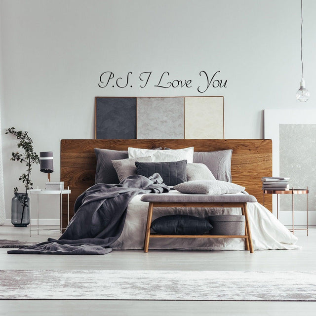 Romantic bedroom featuring a 'P.S. I Love You' wall sticker above a stylish bed with gray bedding and decor.