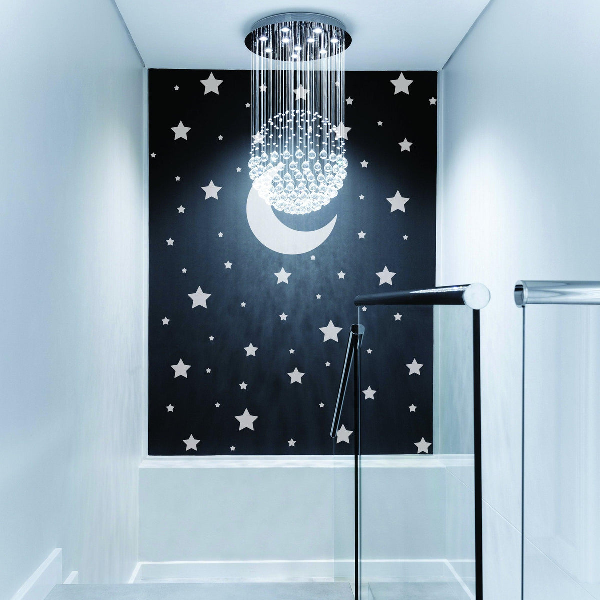 Stylish wall featuring white stars and moon decor in a modern nursery with elegant chandelier lighting.