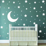 White stars and moon wall stickers in a nursery with a white crib on a green wall.