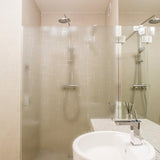 Modern bathroom with frosted shower glass, sleek fixtures, and elegant tile design, showcasing minimalist style.