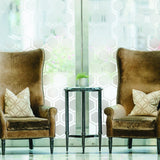 Elegant living room featuring two high-back chairs with stylish cushions and a decorative table.