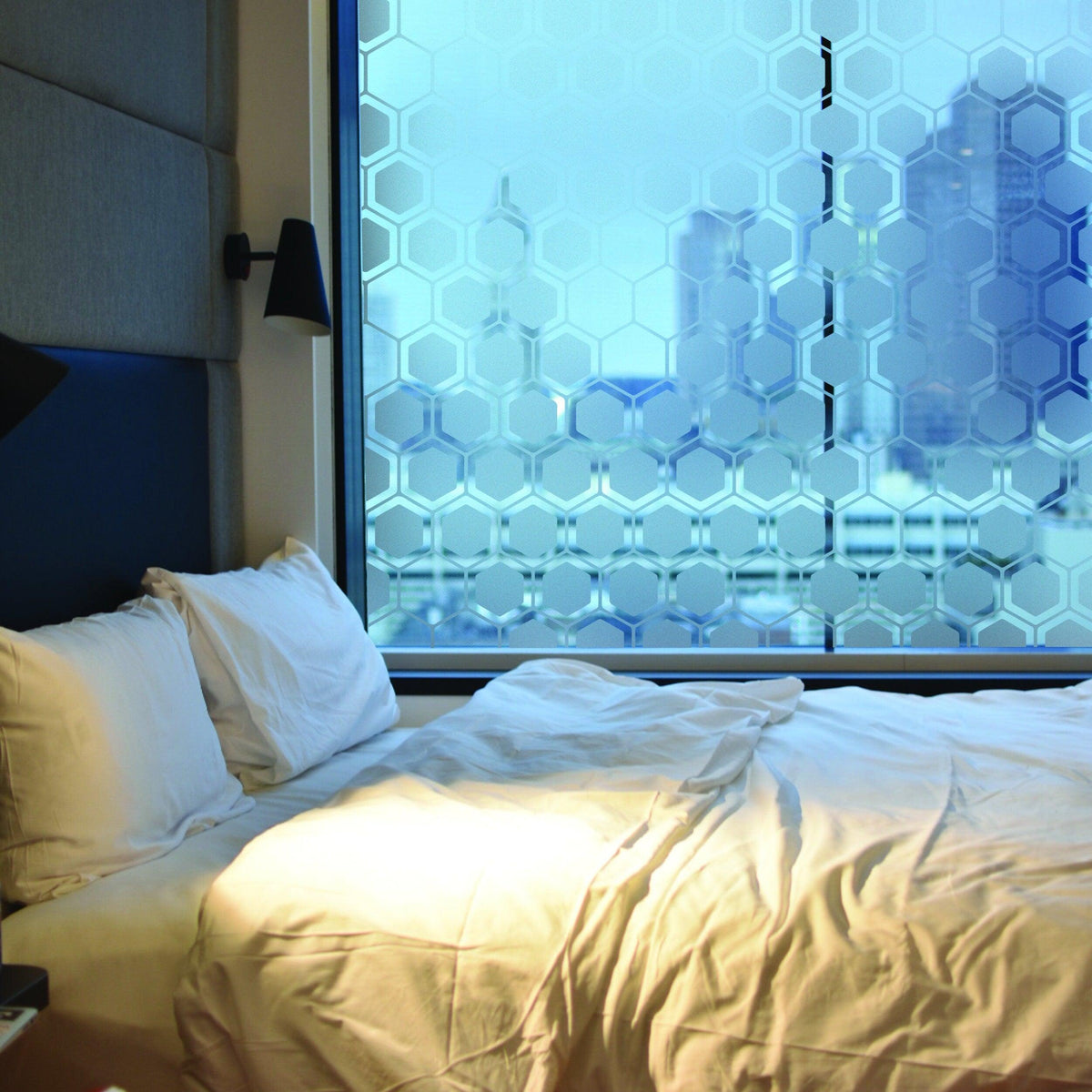 Frosted window decal with honeycomb design in a cozy bedroom setting, enhancing privacy and style.