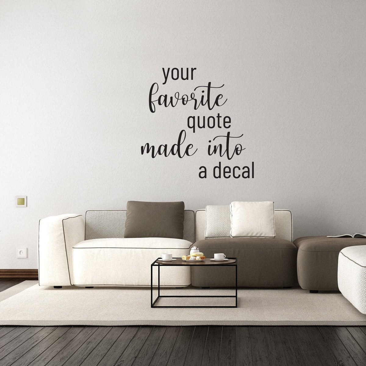 Custom vinyl lettering decal on a wall saying 'your favorite quote made into a decal' above a modern living room couch.