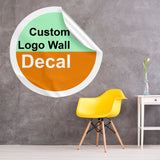 Custom logo wall decal in circular design on a textured wall with a yellow chair and vase.