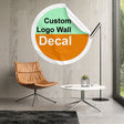 Custom logo wall decal in stylish living room setting with modern chair and lamp.