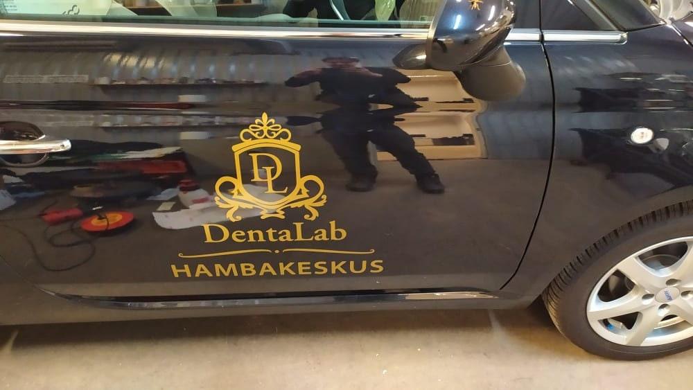 Custom business vinyl decal displayed on a black vehicle.