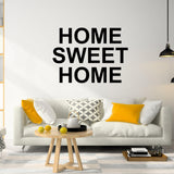 Vinyl removable letter stickers displaying 'Home Sweet Home' on a living room wall above a cozy sofa.