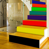 Colorful rainbow self-adhesive stair risers stickers applied on wooden staircase for vibrant home decor.
