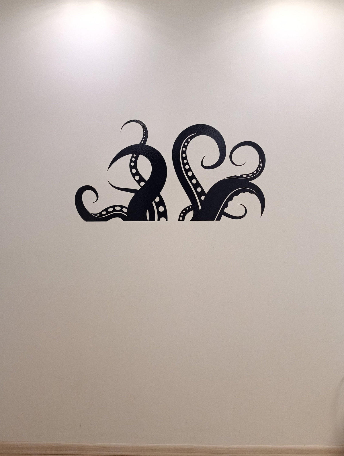 Octopus tentacles vinyl wall art sticker on a light wall, adding ocean-inspired decor to a bathroom space.