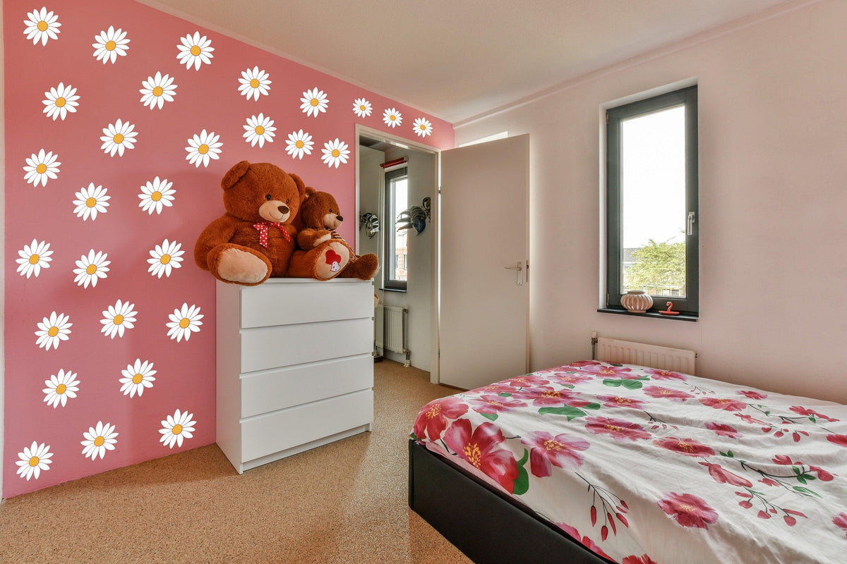 Bright bedroom featuring 24 white daisy wall decals on pink wall, with a flower-patterned bed and teddy bears.