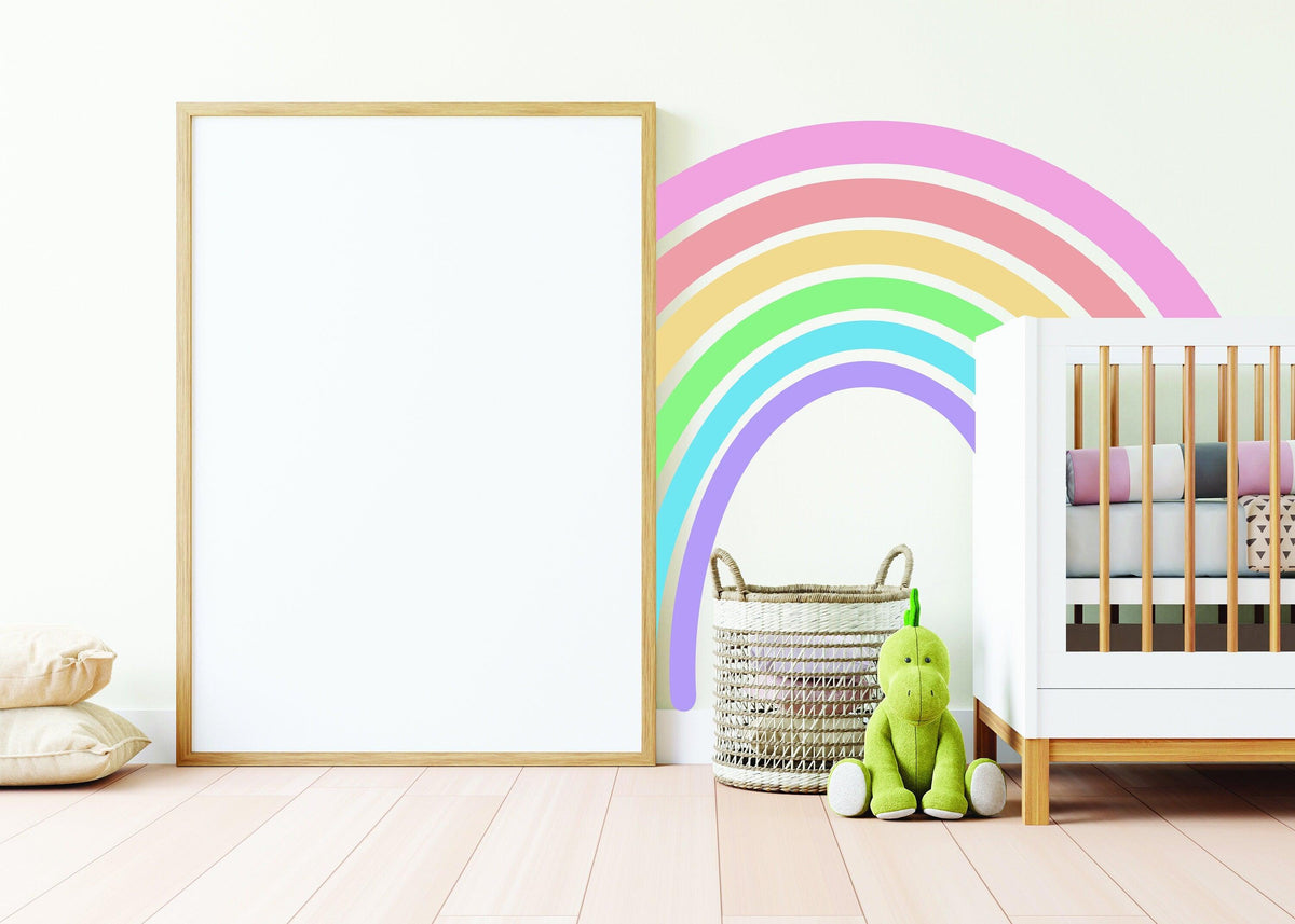 Pastel rainbow adhesive wall sticker above a crib in a nursery, bringing color and cheer to the room.