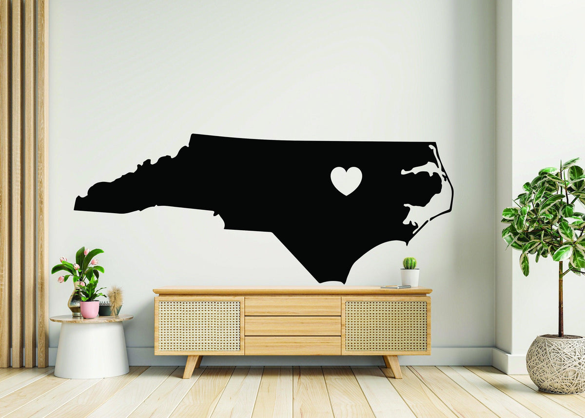 Black vinyl wall decal of North Carolina with a heart cutout.