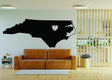 North Carolina wall decal featuring a heart symbol, showcased in a modern living room setting.