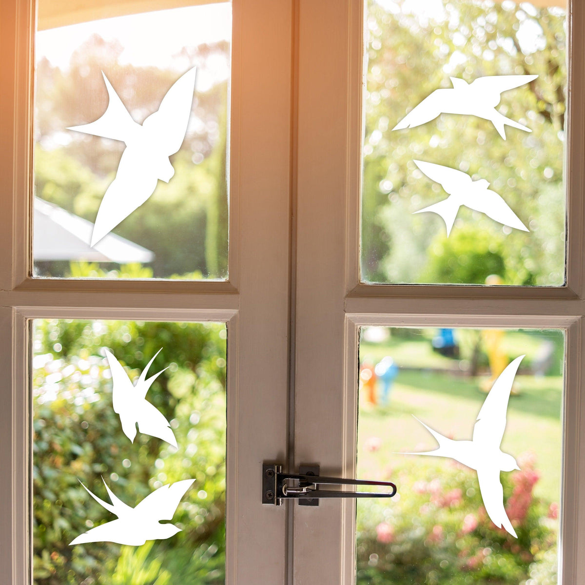 Anti-collision bird decals on a sunny window, effective bird strike deterrents for home safety.
