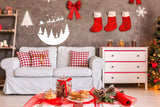 Cozy living room decorated for Christmas with Santa silhouette, red stockings, and festive treats on the table.