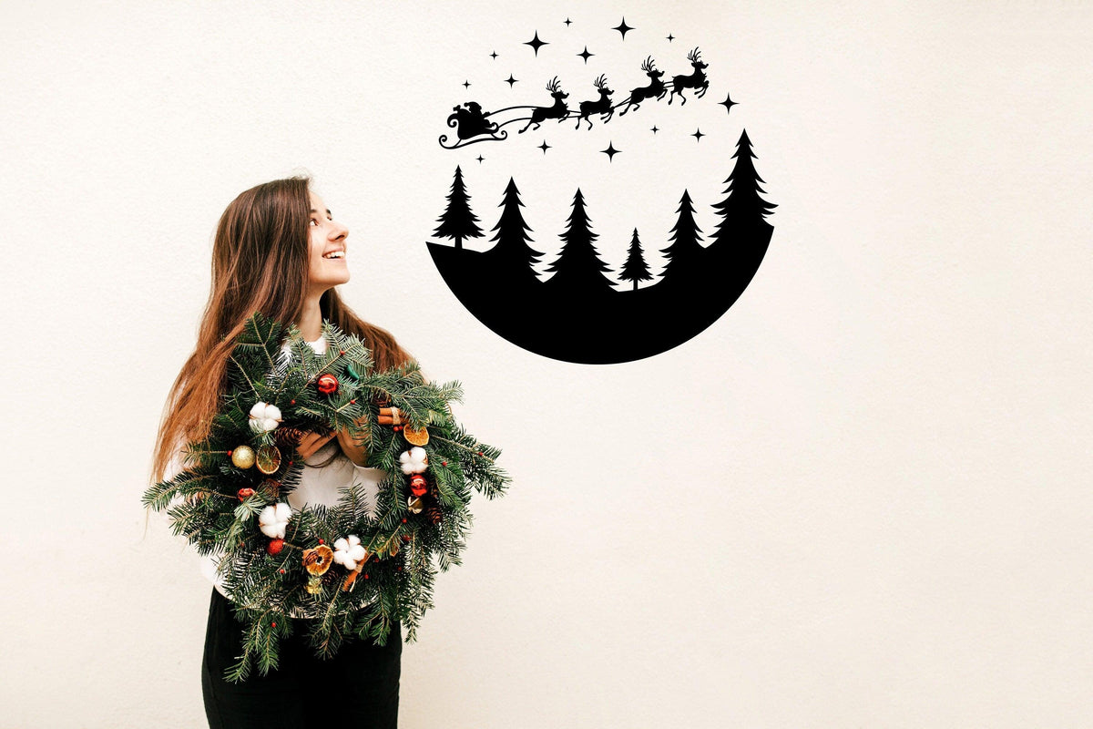 Woman holding a festive wreath with a Circular Santa Sleigh and Deers wall decal above, spreading Christmas cheer.