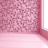 Leopard spot vinyl decals on a pink wall, creating a stylish and cute interior decor.