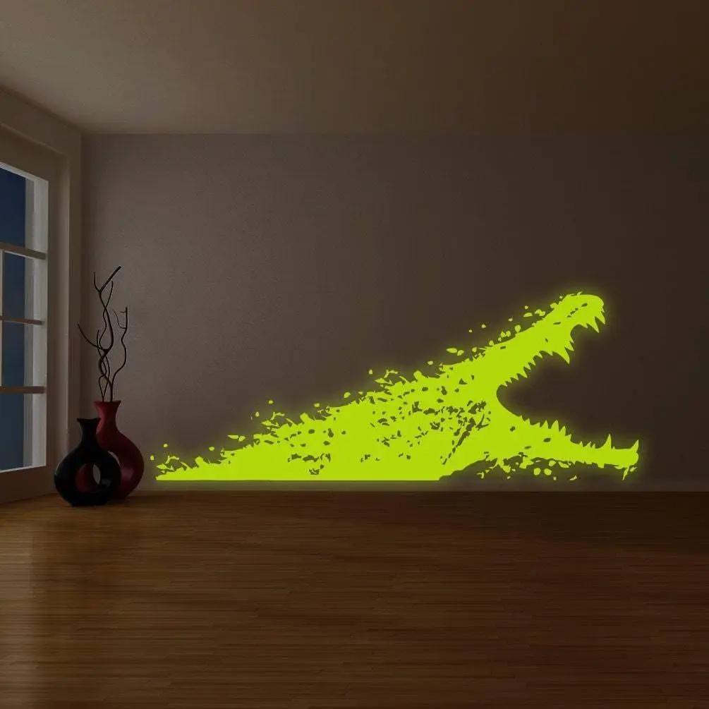 Glow-in-the-dark crocodile wall decal illuminating a living room space with a vibrant green hue.