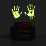 Glowing zombie blood wall decal with bloody handprints illuminating a dark room above a black sofa.